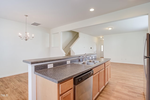 1301 Garden Stone Dr, Raleigh, NC 27610 - kitchen featuring appliances with stainless steel finishes, a center island with sink, light wood finished floors, dark countertops, and a chandelier