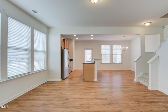 1301 Garden Stone Dr, Raleigh, NC 27610 - kitchen with freestanding refrigerator, light wood-style flooring, open floor plan, dark countertops, and recessed lighting