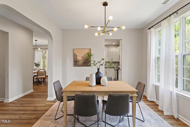 5 Bent Branch Ct, Durham, NC 27704 - dining area featuring a chandelier, wood finished floors, and arched walkways