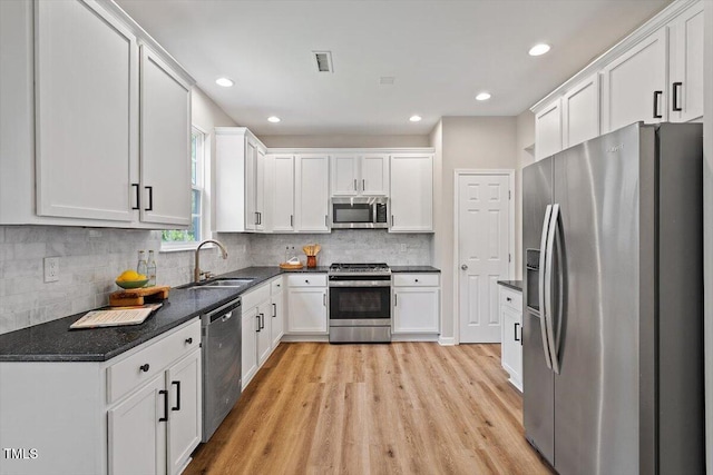 5 Bent Branch Ct, Durham, NC 27704 - kitchen with appliances with stainless steel finishes, white cabinets, light wood finished floors, decorative backsplash, and recessed lighting