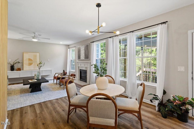 5 Bent Branch Ct, Durham, NC 27704 - dining room with wood finished floors, a glass covered fireplace, a chandelier, and ceiling fan