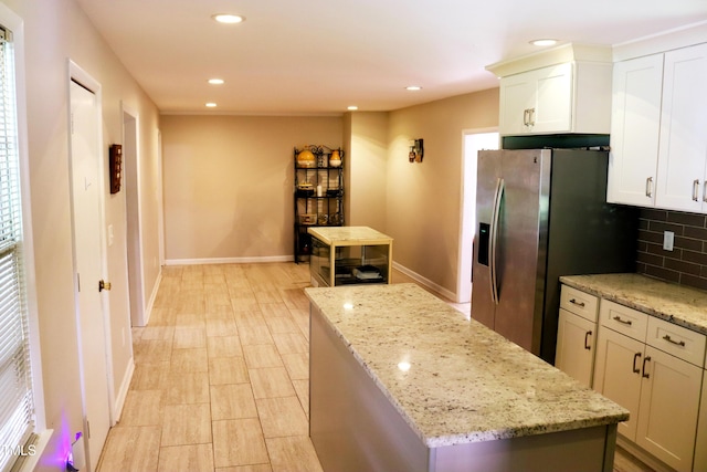 311 Ebon Rd, Durham, NC 27713 - kitchen featuring a center island, stainless steel refrigerator with ice dispenser, backsplash, recessed lighting, and light stone countertops