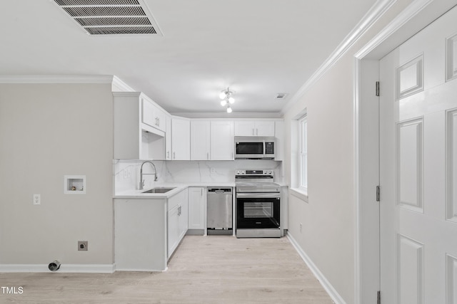 2705 Crest St Unit 3, Durham, NC 27705 - kitchen with stainless steel appliances, tasteful backsplash, light wood-style flooring, crown molding, and white cabinetry