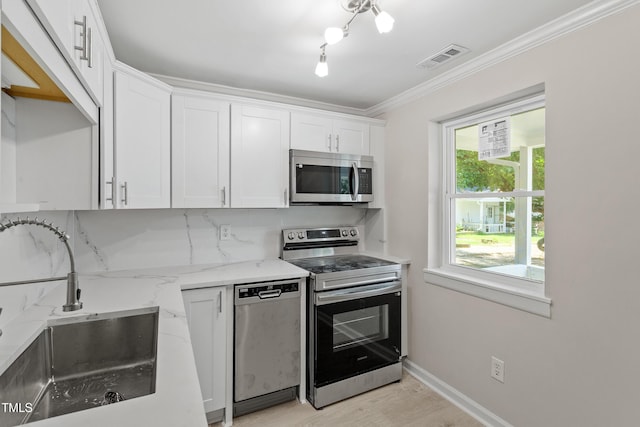 2705 Crest St Unit 3, Durham, NC 27705 - kitchen with stainless steel appliances, white cabinetry, light stone counters, light wood-type flooring, and crown molding