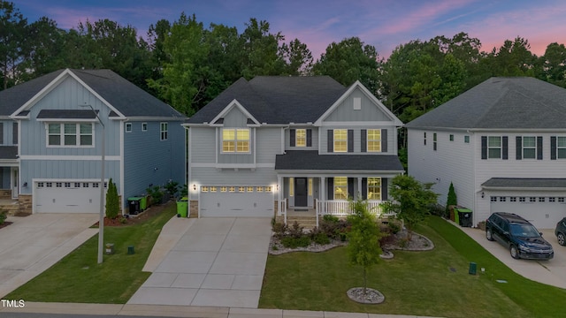 425 Cahors Trl, Holly Springs, NC 27540 - view of front of house with board and batten siding, a porch, concrete driveway, an attached garage, and a yard