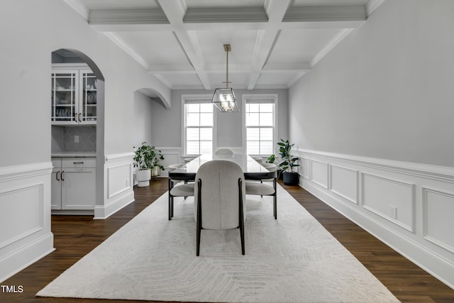 425 Cahors Trl, Holly Springs, NC 27540 - dining space featuring coffered ceiling, arched walkways, beamed ceiling, a chandelier, and dark wood-type flooring