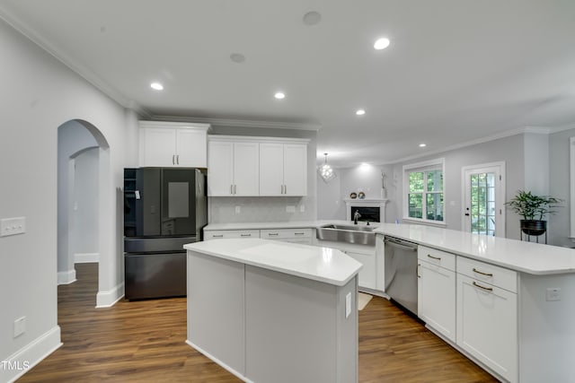 425 Cahors Trl, Holly Springs, NC 27540 - kitchen with freestanding refrigerator, stainless steel dishwasher, ornamental molding, arched walkways, and a peninsula