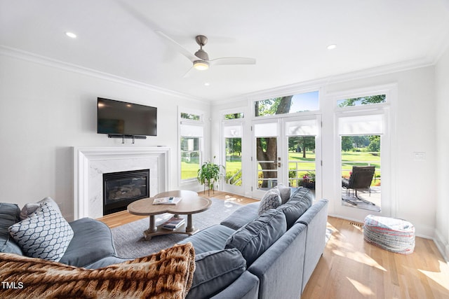 781 Crabtree Crossing Pkwy, Cary, NC 27513 - living area with ornamental molding, light wood-type flooring, a ceiling fan, a fireplace, and recessed lighting