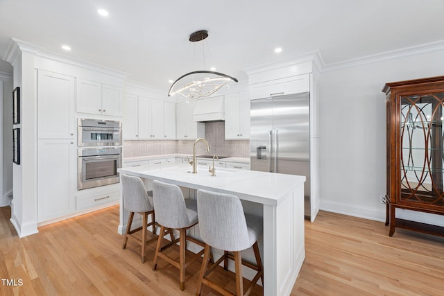781 Crabtree Crossing Pkwy, Cary, NC 27513 - kitchen with appliances with stainless steel finishes, light countertops, backsplash, a chandelier, and light wood-type flooring