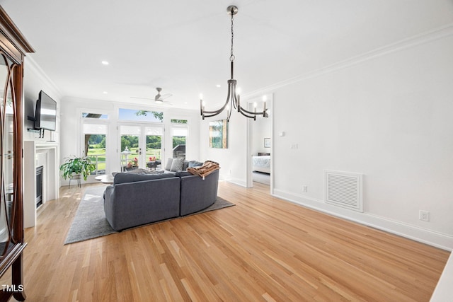 781 Crabtree Crossing Pkwy, Cary, NC 27513 - living room with crown molding, french doors, light wood-style flooring, a fireplace, and recessed lighting