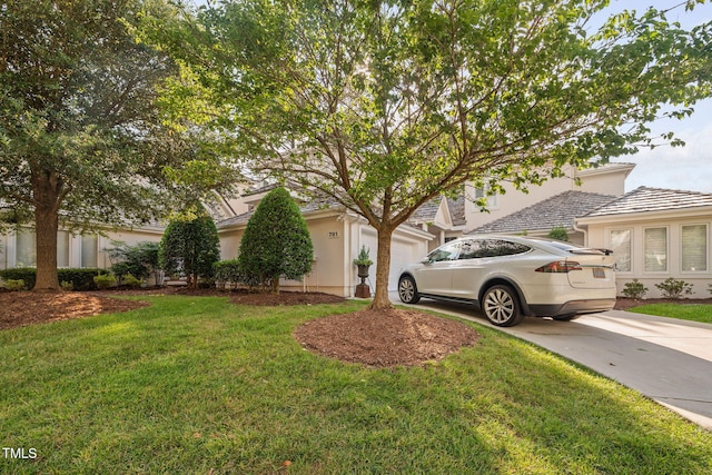 781 Crabtree Crossing Pkwy, Cary, NC 27513 - view of side of property featuring driveway, a garage, stucco siding, and a lawn