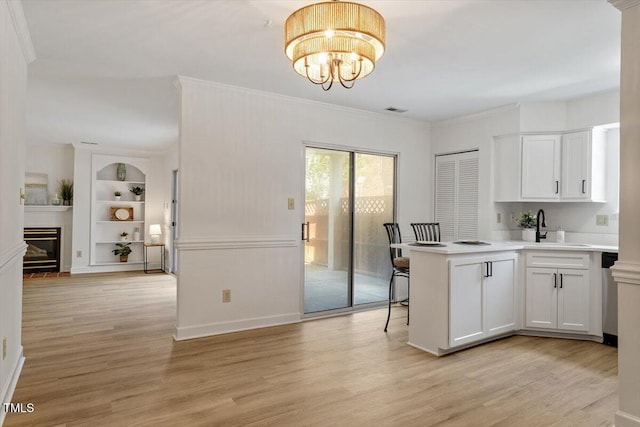 449 Summerwalk Cir, Chapel Hill, NC 27517 - kitchen featuring built in features, light wood-style flooring, ornamental molding, a chandelier, and white cabinets
