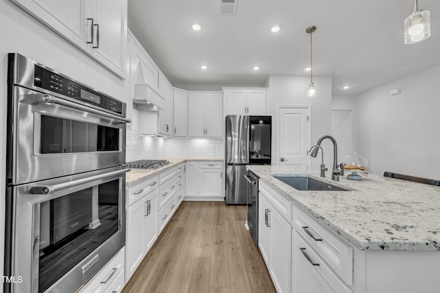 115 Circle City Way, Pittsboro, NC 27312 - kitchen featuring appliances with stainless steel finishes, light wood finished floors, white cabinetry, tasteful backsplash, and recessed lighting
