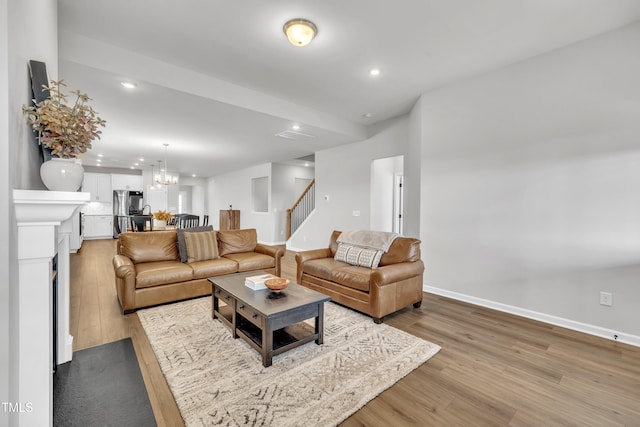 115 Circle City Way, Pittsboro, NC 27312 - living area featuring stairs, light wood finished floors, recessed lighting, and a chandelier