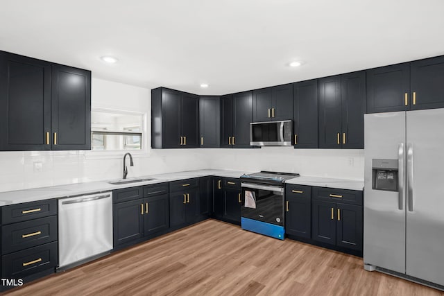 1907 Wilkins St, Burlington, NC 27217 - kitchen with stainless steel appliances, light wood finished floors, tasteful backsplash, light stone countertops, and dark cabinets