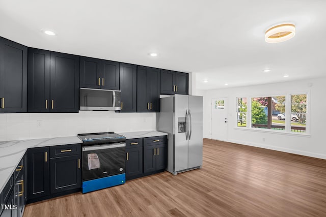 1907 Wilkins St, Burlington, NC 27217 - kitchen featuring stainless steel appliances, light wood-type flooring, dark cabinets, backsplash, and recessed lighting