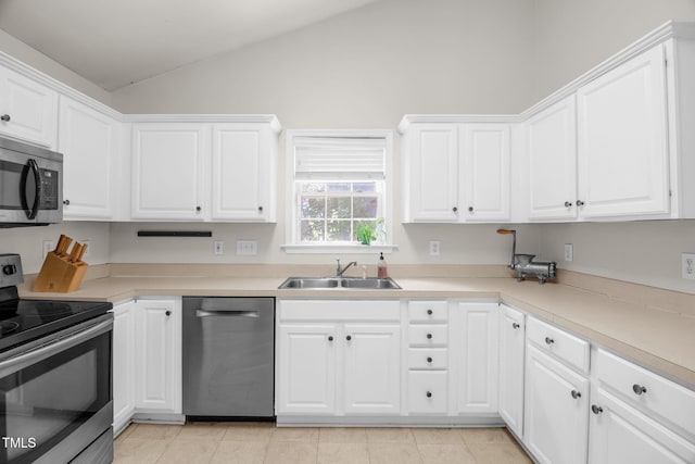 6001 Black Willow Dr, Greensboro, NC 27405 - kitchen with stainless steel appliances, vaulted ceiling, white cabinetry, light tile patterned flooring, and light countertops