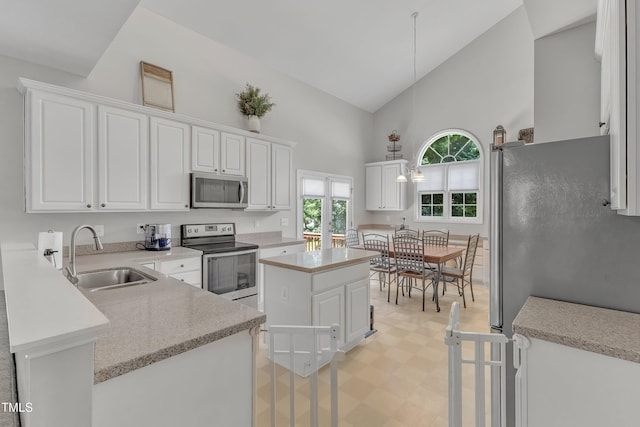 13201 Townfield Dr, Raleigh, NC 27614 - kitchen featuring stainless steel appliances, high vaulted ceiling, white cabinets, light floors, and a center island