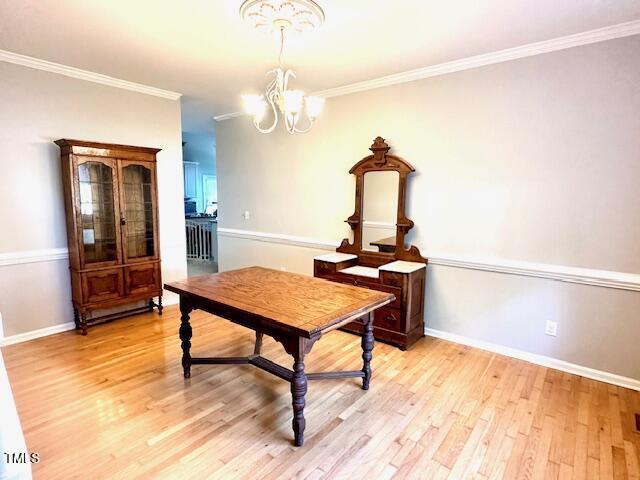 13201 Townfield Dr, Raleigh, NC 27614 - dining area featuring a chandelier, light wood-style floors, and ornamental molding