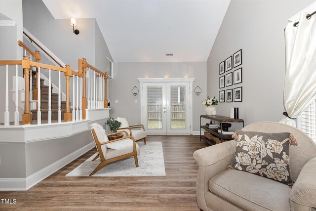 5609 Edgebury Rd, Raleigh, NC 27613 - living area with wood finished floors, stairway, french doors, and vaulted ceiling
