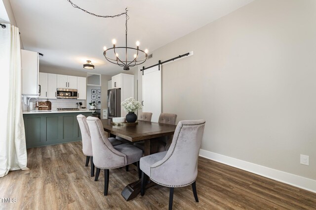 5609 Edgebury Rd, Raleigh, NC 27613 - dining space with a barn door, wood finished floors, and a chandelier