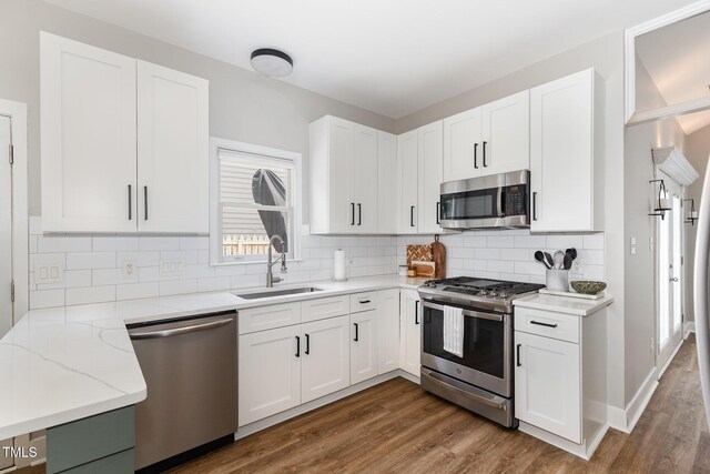5609 Edgebury Rd, Raleigh, NC 27613 - kitchen featuring stainless steel appliances, dark wood-type flooring, light stone countertops, and white cabinetry
