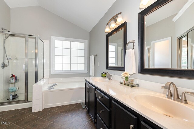 5609 Edgebury Rd, Raleigh, NC 27613 - bathroom featuring a garden tub, vaulted ceiling, double vanity, a stall shower, and plenty of natural light
