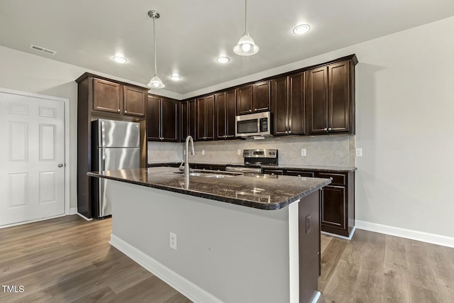 245 E Webber Ln, Clayton, NC 27527 - kitchen with stainless steel appliances, dark brown cabinetry, dark stone countertops, wood finished floors, and recessed lighting