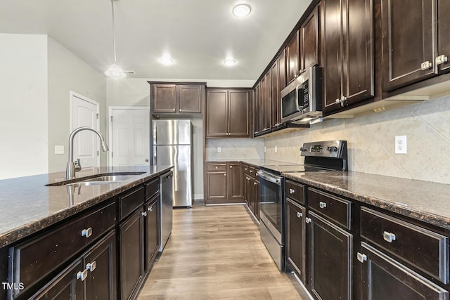 245 E Webber Ln, Clayton, NC 27527 - kitchen with appliances with stainless steel finishes, dark stone counters, dark brown cabinetry, light wood finished floors, and recessed lighting