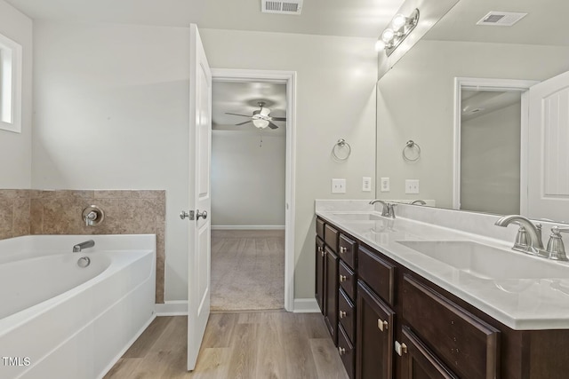 245 E Webber Ln, Clayton, NC 27527 - bathroom with wood finished floors, double vanity, a bath, and ceiling fan