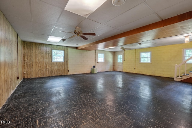 906 Cindy St, Cary, NC 27511 - basement with a ceiling fan, a drop ceiling, healthy amount of natural light, wood walls, and stairs