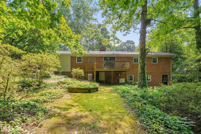 906 Cindy St, Cary, NC 27511 - back of house featuring brick siding, a wooden deck, a chimney, and a lawn
