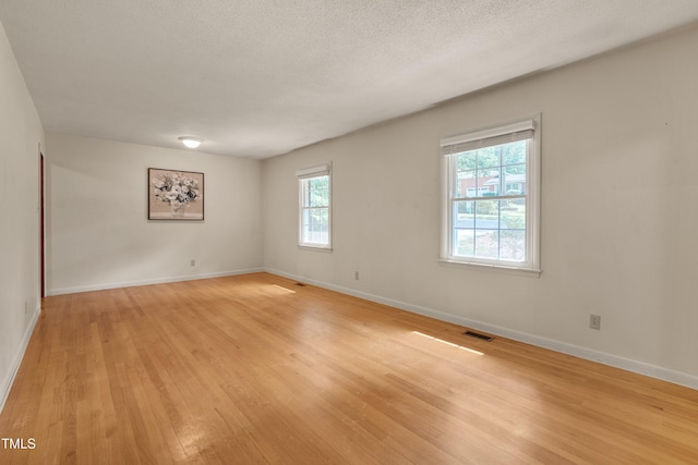 906 Cindy St, Cary, NC 27511 - spare room with light wood-style flooring and a textured ceiling
