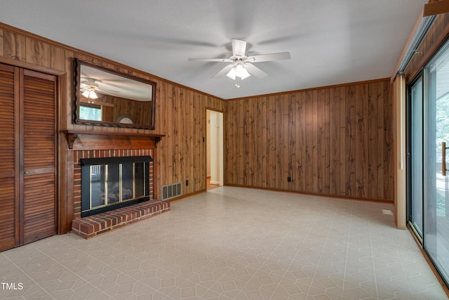 906 Cindy St, Cary, NC 27511 - unfurnished living room with a ceiling fan, crown molding, wood walls, healthy amount of natural light, and light flooring