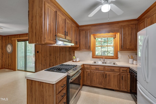906 Cindy St, Cary, NC 27511 - kitchen featuring stainless steel range with gas cooktop, freestanding refrigerator, ceiling fan, brown cabinets, and wood walls