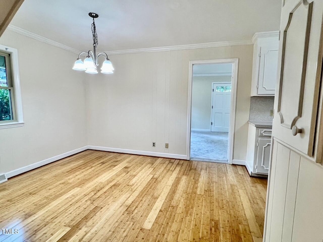 612 Williamsboro St, Oxford, NC 27565 - unfurnished dining area with light wood-style flooring, crown molding, and a chandelier