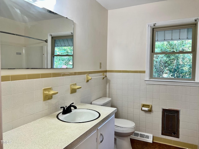 612 Williamsboro St, Oxford, NC 27565 - bathroom with vanity, a shower, tile walls, heating unit, and wainscoting