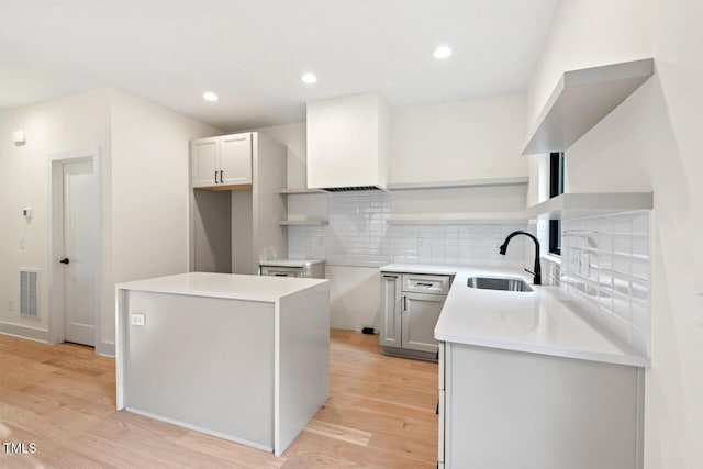 2205 Tampa Ave, Durham, NC 27705 - kitchen with open shelves, light wood-style floors, tasteful backsplash, recessed lighting, and custom range hood