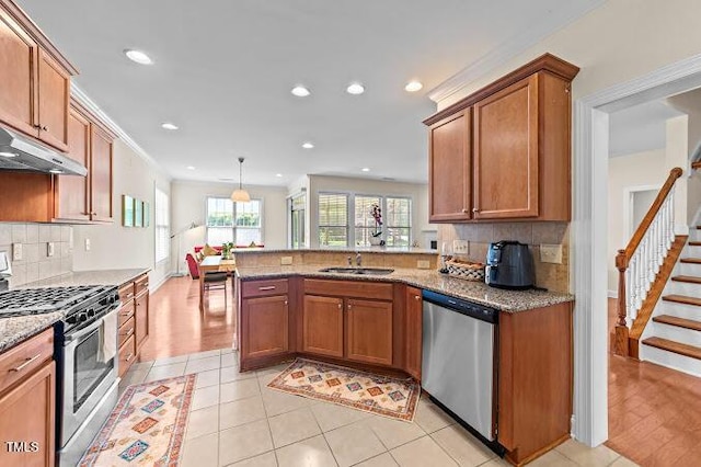 4007 Strendal Dr, Cary, NC 27519 - kitchen featuring stainless steel appliances, brown cabinets, tasteful backsplash, recessed lighting, and a peninsula