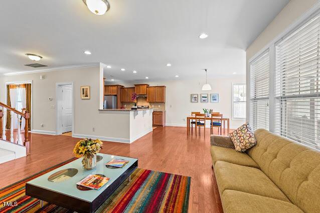 4007 Strendal Dr, Cary, NC 27519 - living room with wood finished floors, stairway, recessed lighting, and ornamental molding