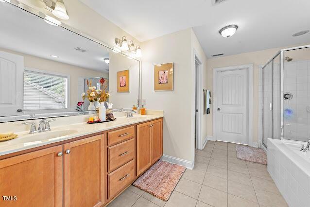 4007 Strendal Dr, Cary, NC 27519 - bathroom featuring double vanity, a shower stall, tile patterned flooring, and tiled tub