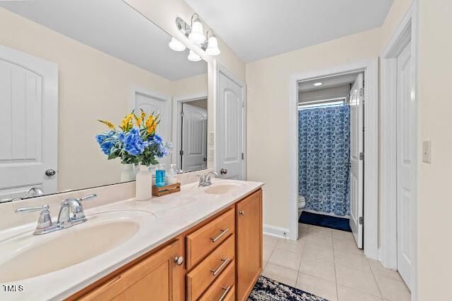 4007 Strendal Dr, Cary, NC 27519 - full bath with double vanity, tile patterned flooring, and a shower with shower curtain
