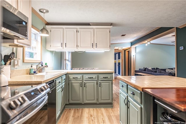 1360 Rays Bridge Rd, Whispering Pines, NC 28327 - kitchen with appliances with stainless steel finishes, green cabinetry, a textured ceiling, crown molding, and light wood-style floors
