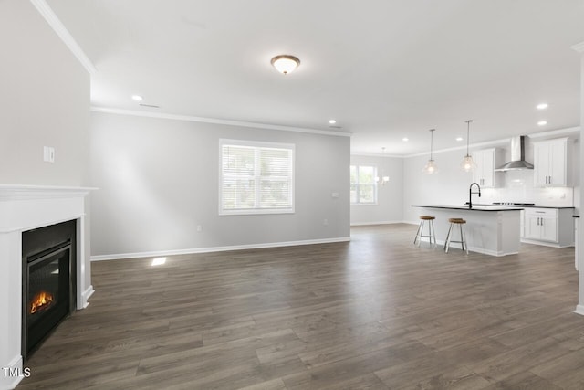 1409 Jasmine View Way, Knightdale, NC 27545 - unfurnished living room with crown molding, recessed lighting, a glass covered fireplace, and dark wood-style flooring
