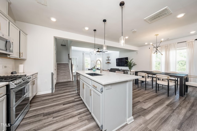 1143 Sweet Cream Ct, Durham, NC 27703 - kitchen with appliances with stainless steel finishes, light wood-style floors, light countertops, healthy amount of natural light, and recessed lighting