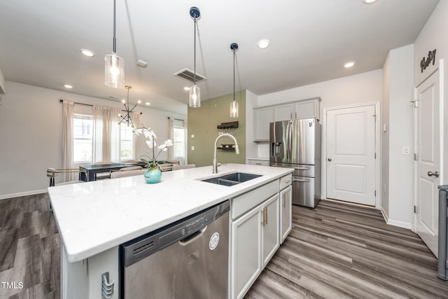 1143 Sweet Cream Ct, Durham, NC 27703 - kitchen with stainless steel appliances, a kitchen island with sink, recessed lighting, decorative light fixtures, and dark wood-style flooring