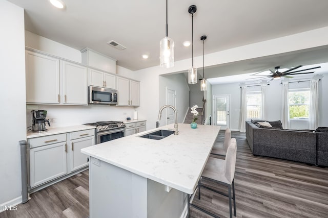 1143 Sweet Cream Ct, Durham, NC 27703 - kitchen with appliances with stainless steel finishes, recessed lighting, open floor plan, dark wood-type flooring, and a breakfast bar area