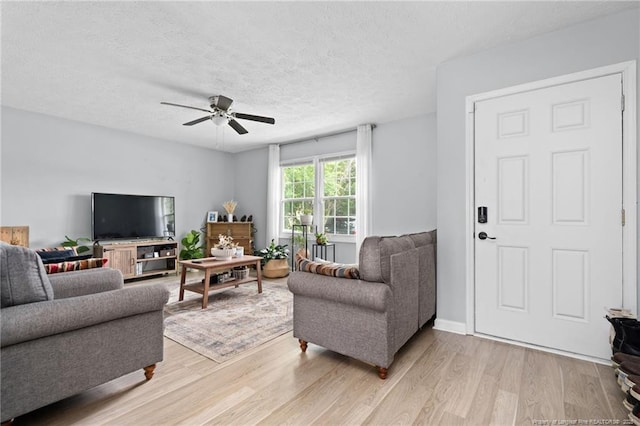 4450 Chesterbrook Dr, Fayetteville, NC 28314 - living room with light wood finished floors, a ceiling fan, and a textured ceiling