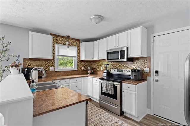 4450 Chesterbrook Dr, Fayetteville, NC 28314 - kitchen featuring stainless steel appliances, tasteful backsplash, white cabinets, and a textured ceiling