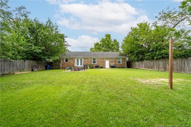 4450 Chesterbrook Dr, Fayetteville, NC 28314 - rear view of property featuring a fenced backyard, french doors, and brick siding
